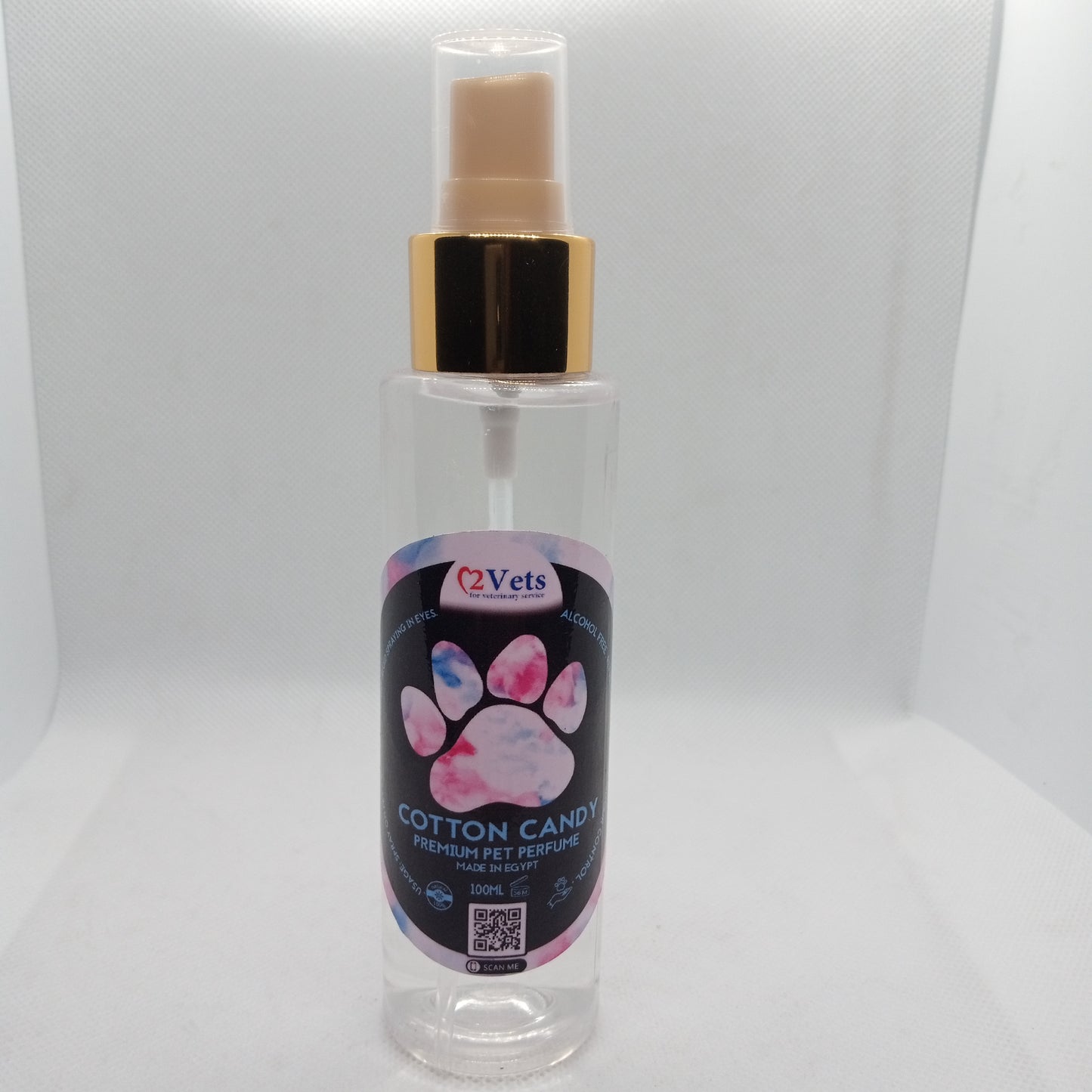Clear spray bottle with a gold nozzle and pink paw print label on a white background