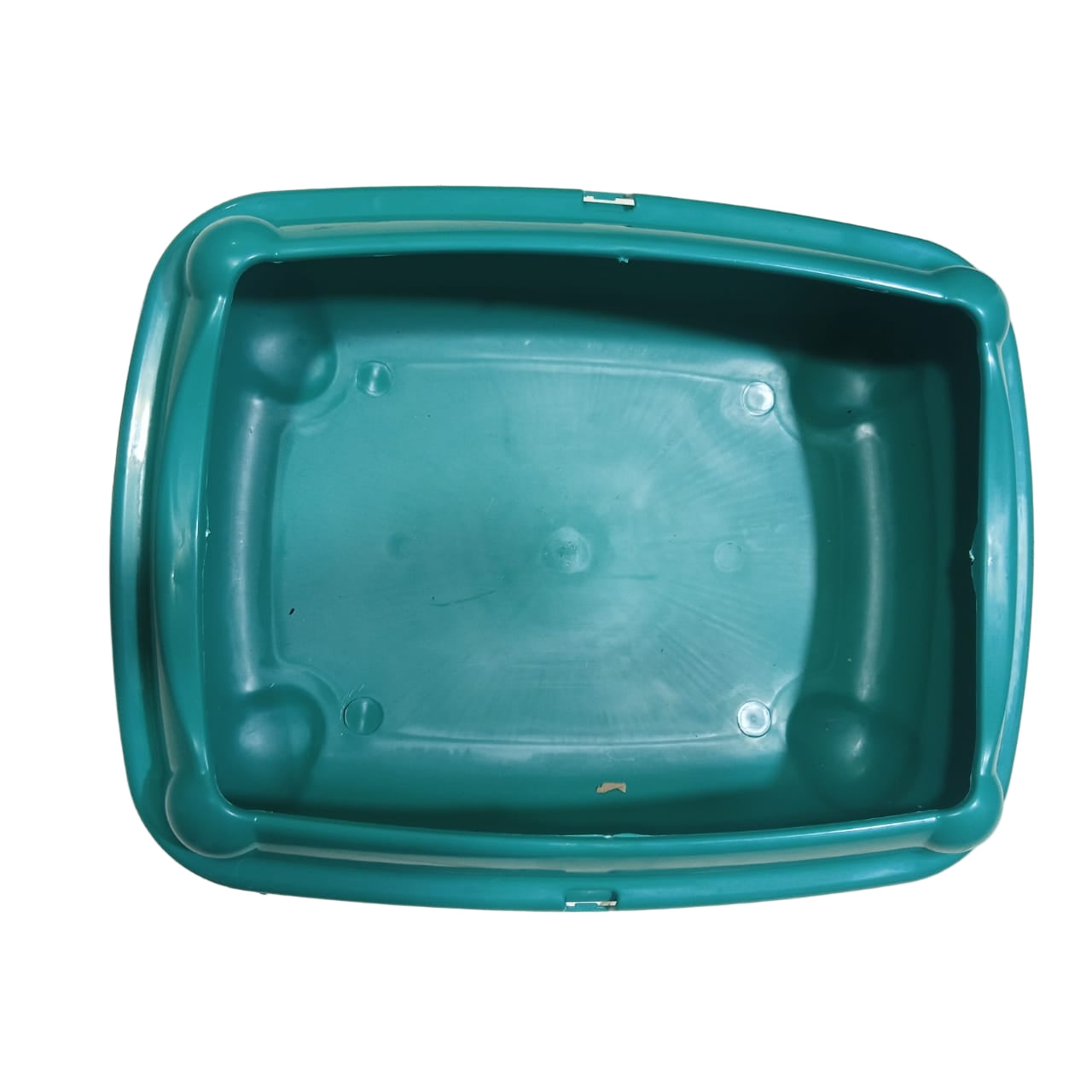 Green plastic tray on a tiled floor